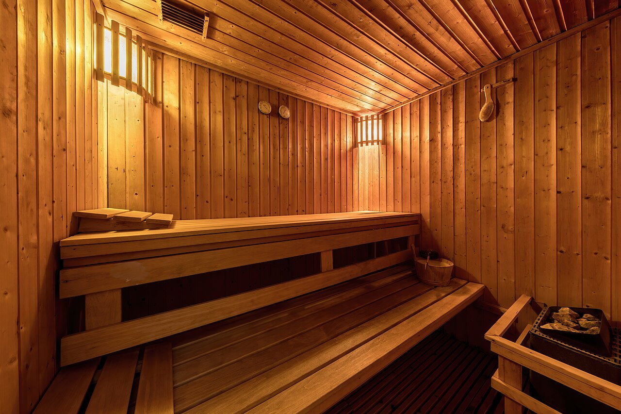 Interno di sauna con panche in legno e stufa